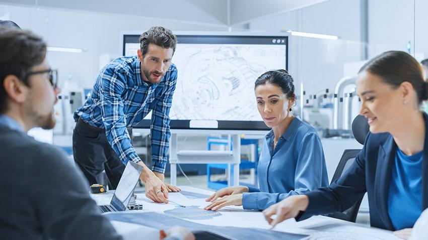 Modern Factory Office Meeting Room: Busy Diverse Team of Engineers, Managers and Investors Talking at Conference Table, Use Interactive TV, Analyze, Find Solutions, Debate and Discuss Engine Concept